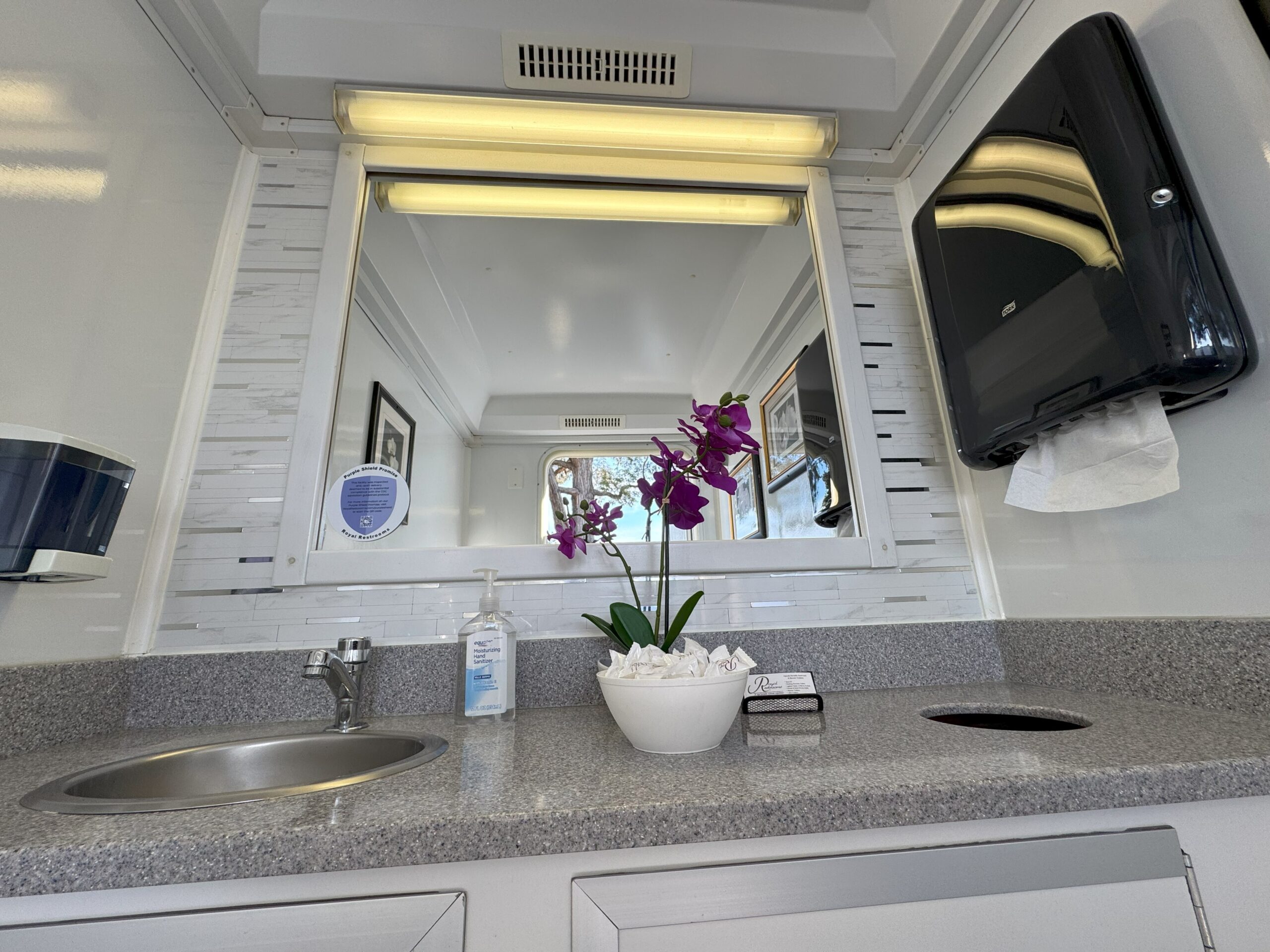 Restroom vanity with brown countertop and orchid